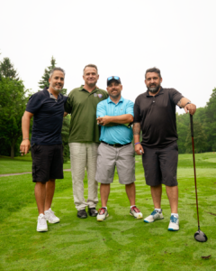4 OETIO Staff members stand side by side on a golf course.