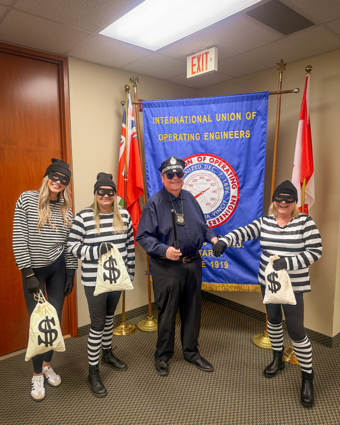 793 Business Manager Mike Gallagher dressed as a police officer with 3 793 staff members dressed as criminals