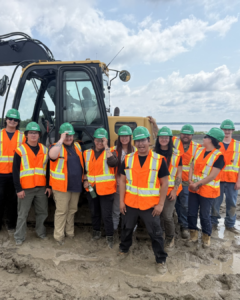 a group of pre-apprentices stand in front of an excavator