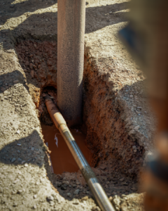 a hole with water in the ground with pipes running into it