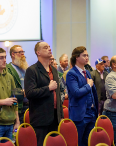 A group of people standing from their seats