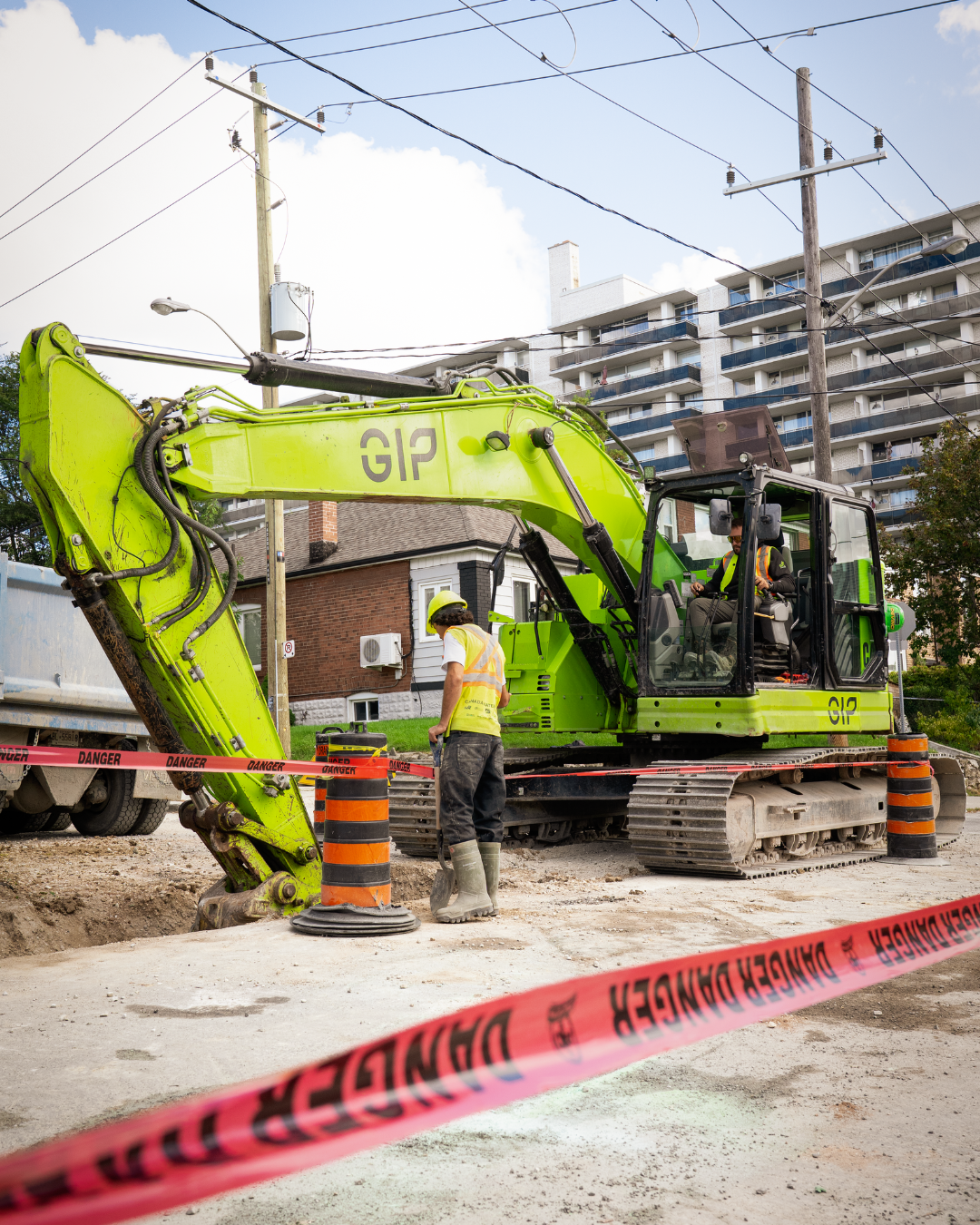Two members wearing proper P.P.E working on a construction site in a residential area