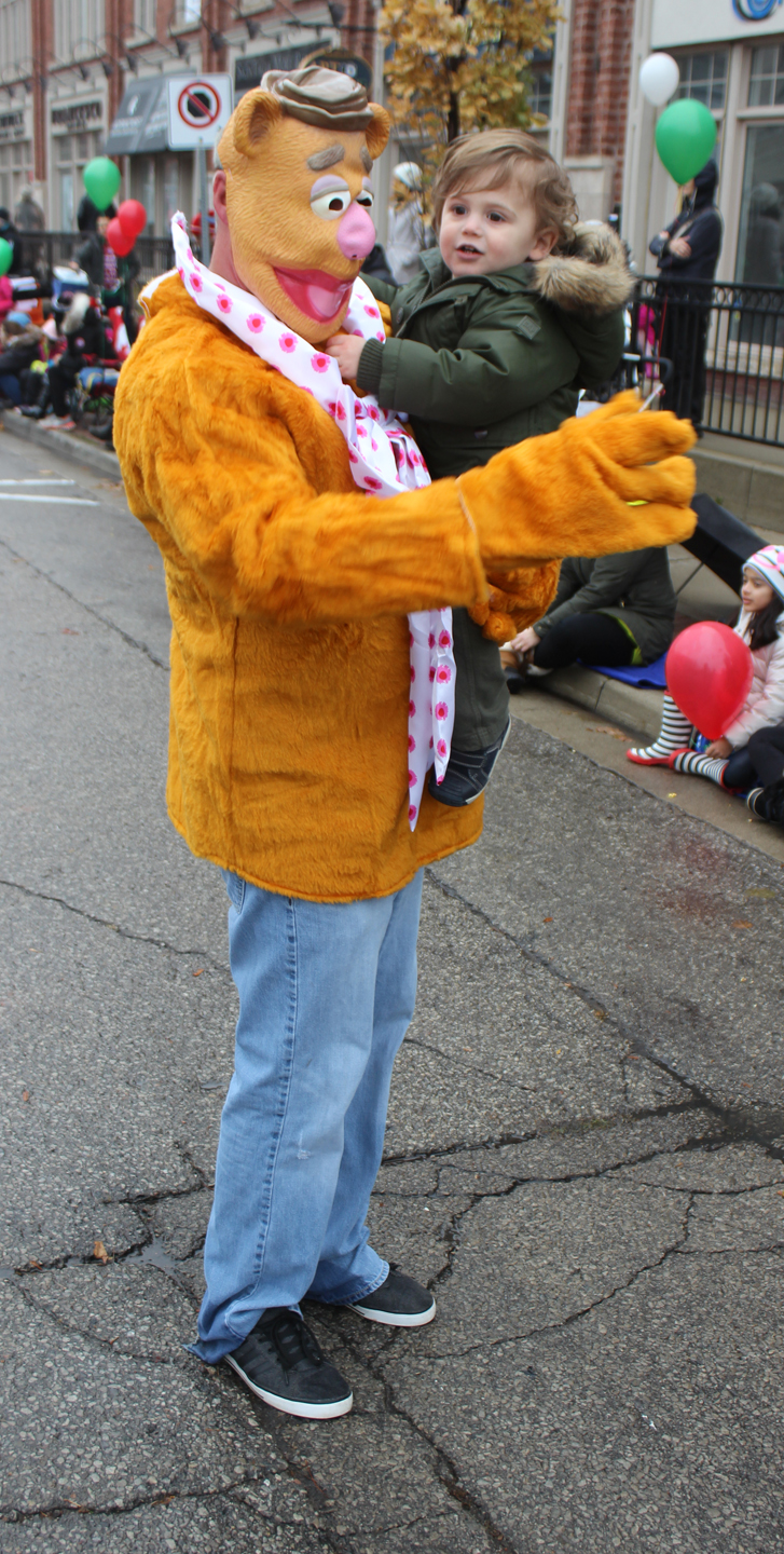 A Local 793 member gives a child a lift dressed as Fozzie Bear from the Muppets.