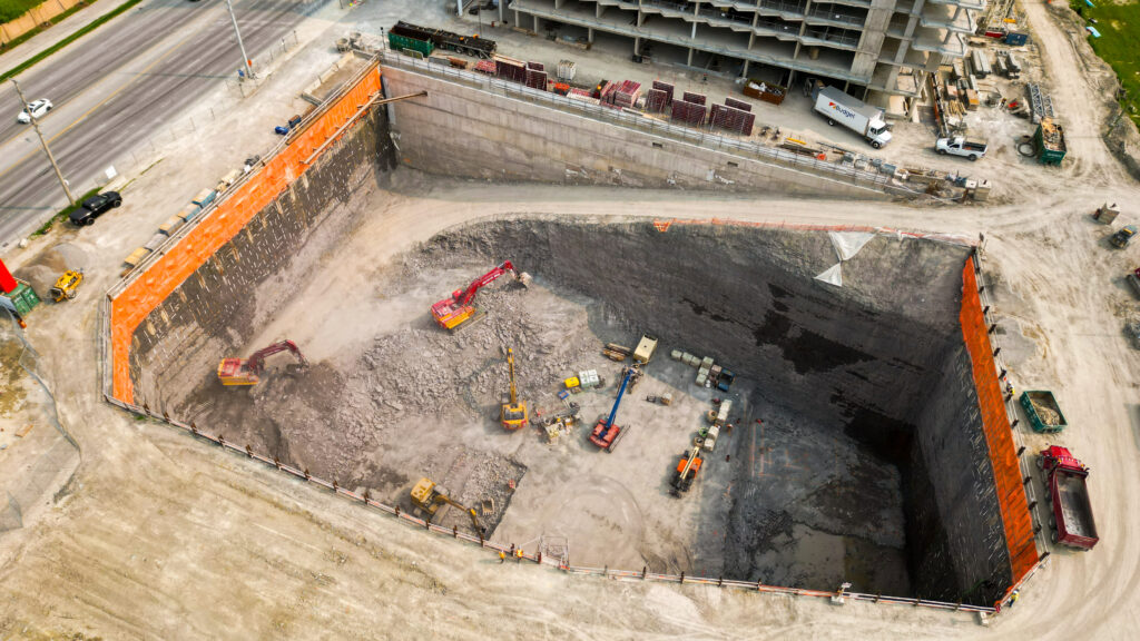 Drone image of the excavated site with heavy equipment and members