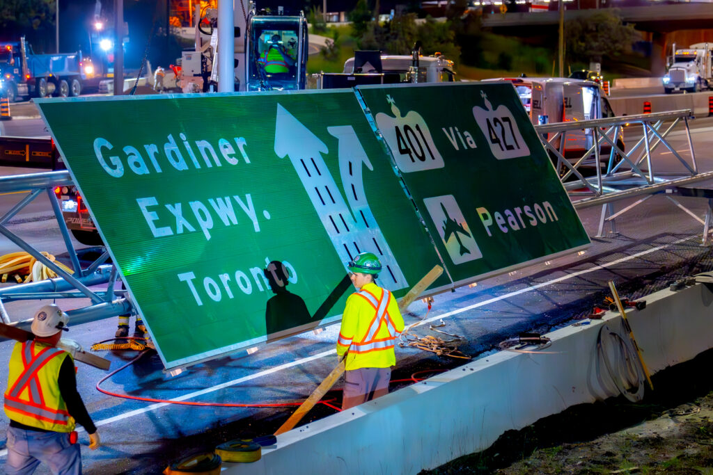 Close up of the road sign on the road before installation with workers around it