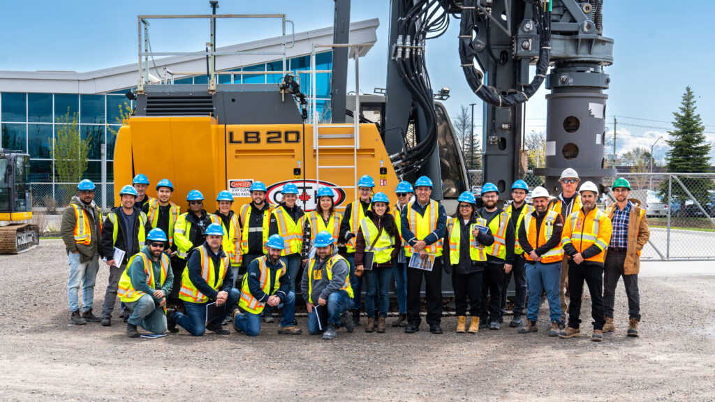 Inspectors from Ontario's Ministry of Labour, Immigration, Training and Skills Development (MLITSD) and OETIO students posed in front of a drill rig