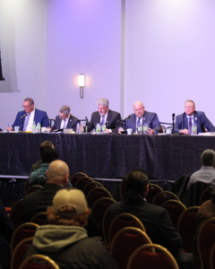 5 men sit as a long table in front of an audience. In order: Steve Booze, Brian Alexander, Rick Kerr, Mike Scott, and 793 President Dave Turple