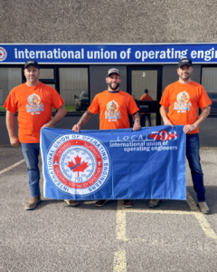Sarnia office staff wearing orange shirts holding an IUOE Local 793 Banner