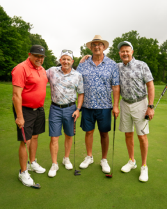 4 IUOE 793 Staff members stand side by side smiling on a golf course.