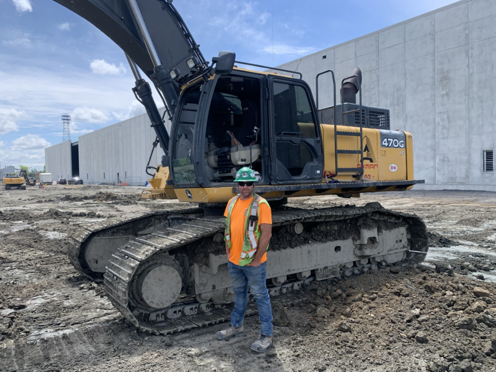 Image of Alain Turcot in front of a 470G LC Excavator