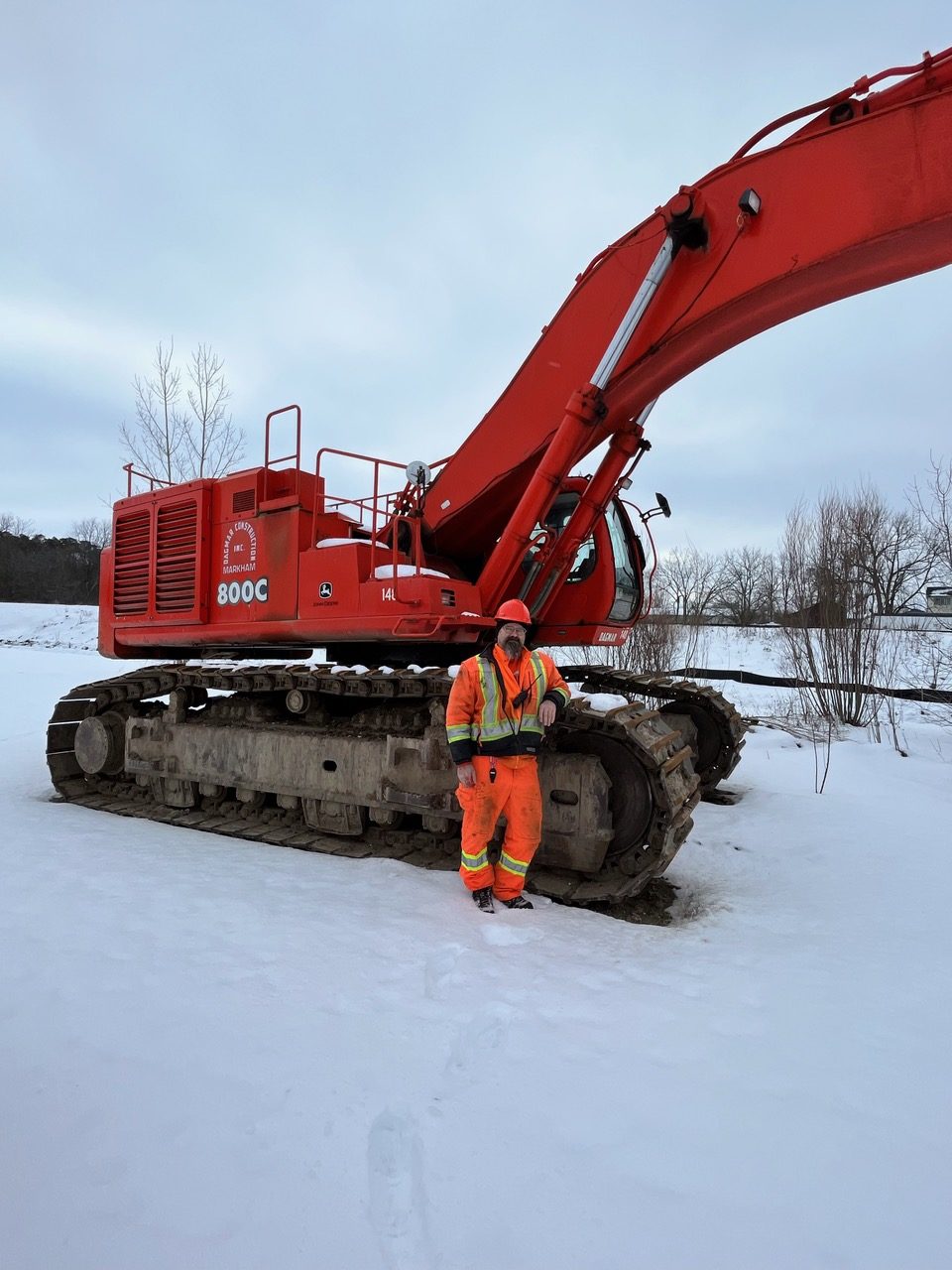 Member posing and leaning back on excavator