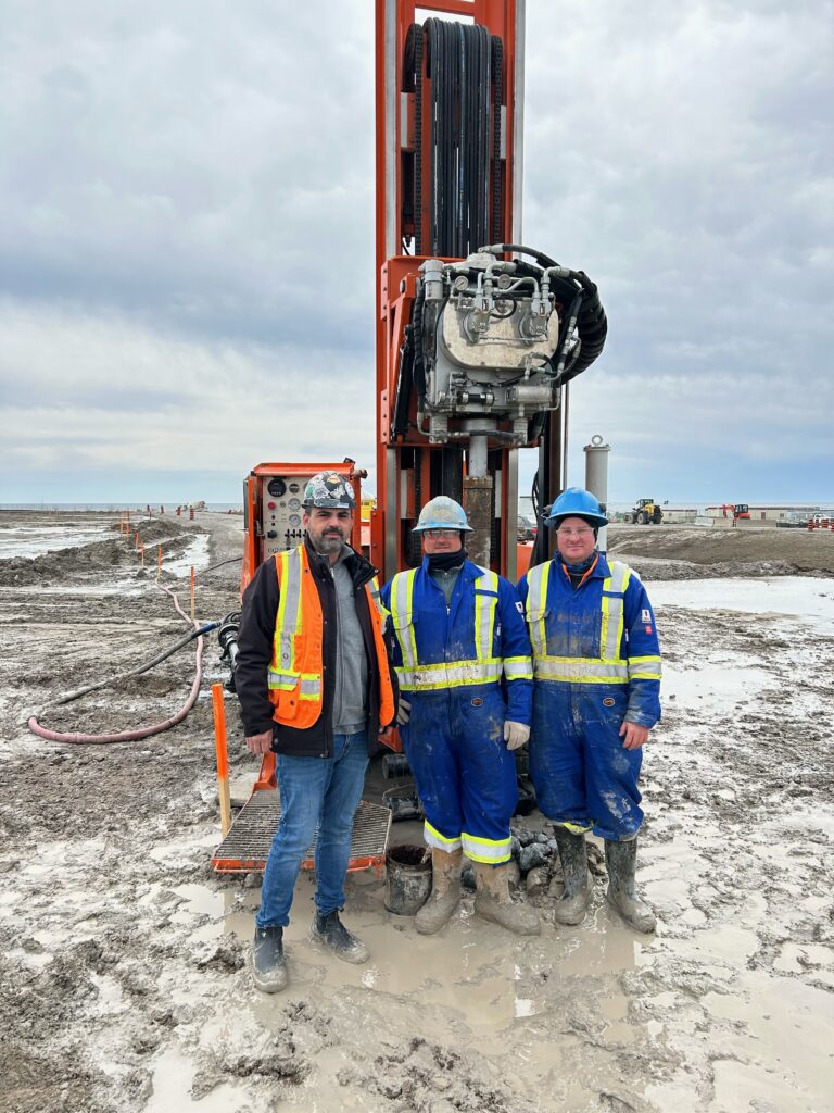 Union members pose next to drill rig