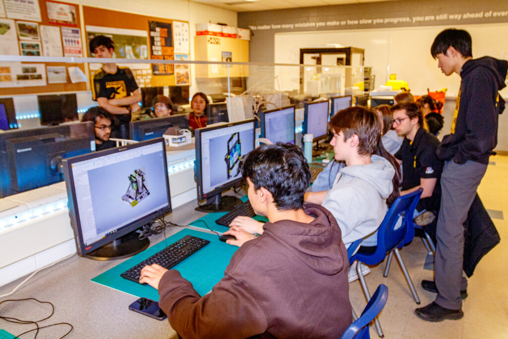 Students fine tune their robot's design on their computers