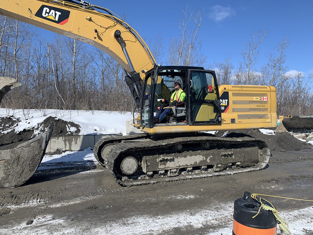 Local 793 member Frank Smith works on installing storm pipes in a 336 Cat excavator.