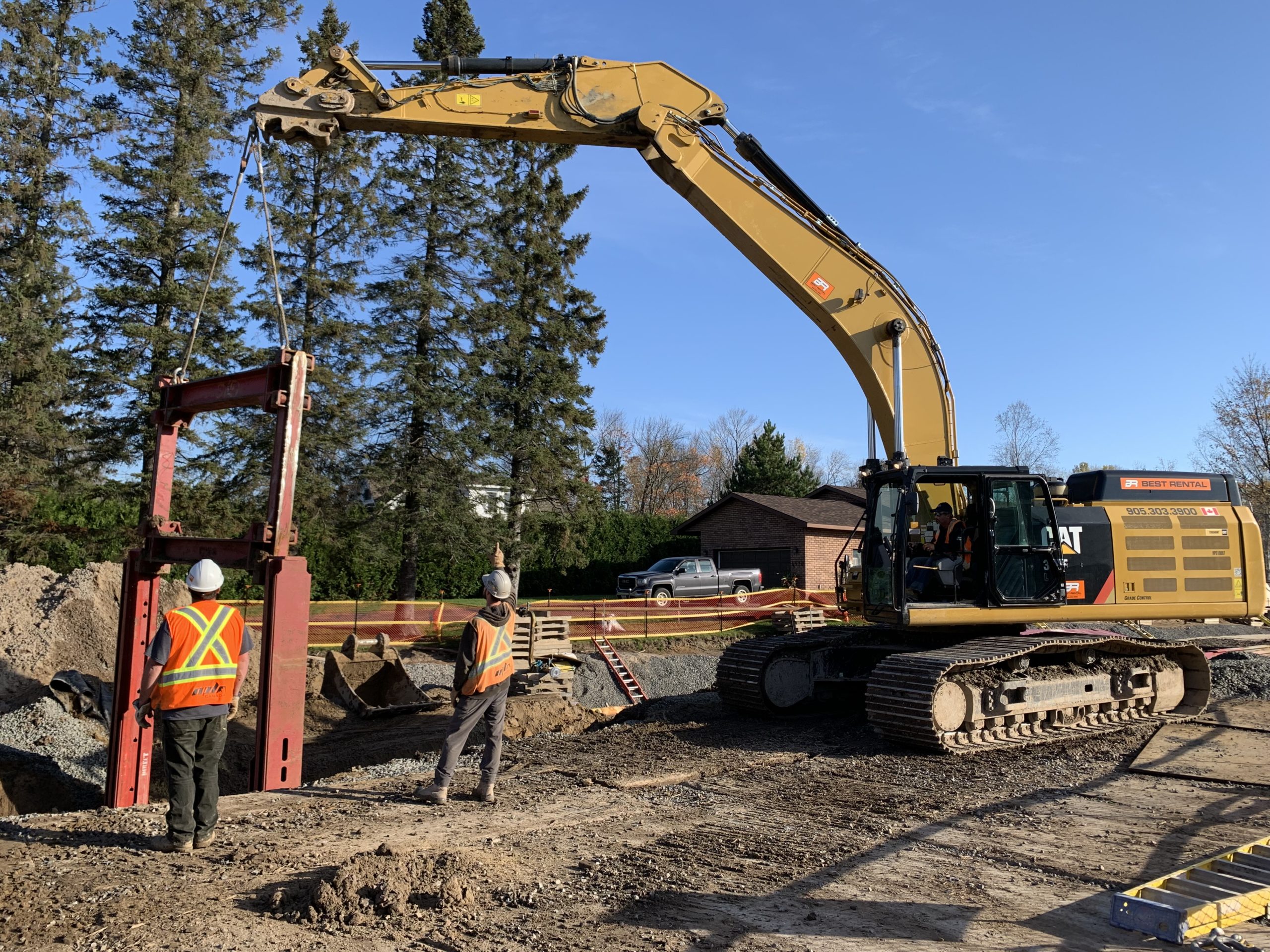 Foreman Waylon Spicer and Brandon Wolsing are assisting Kevin Robidoux who is operating a Cat 349 excavator.