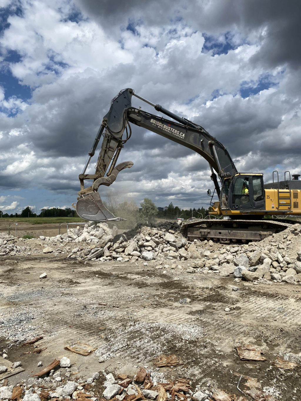 Jonathan Cunninghham moves concrete rubble in a John Deere 450D excavator.
