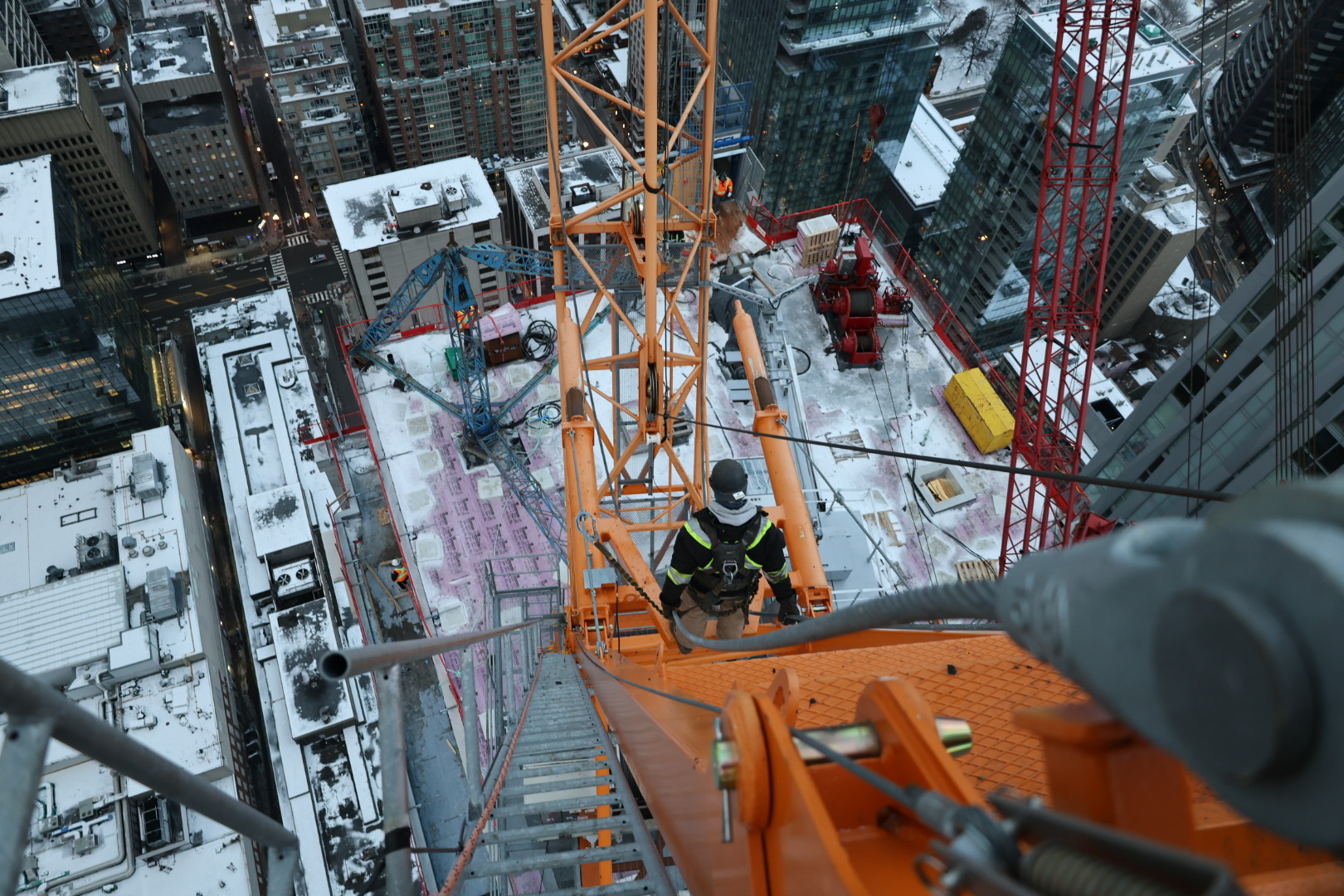 Steep shot of the height of the crane and a member climbing down the stairs