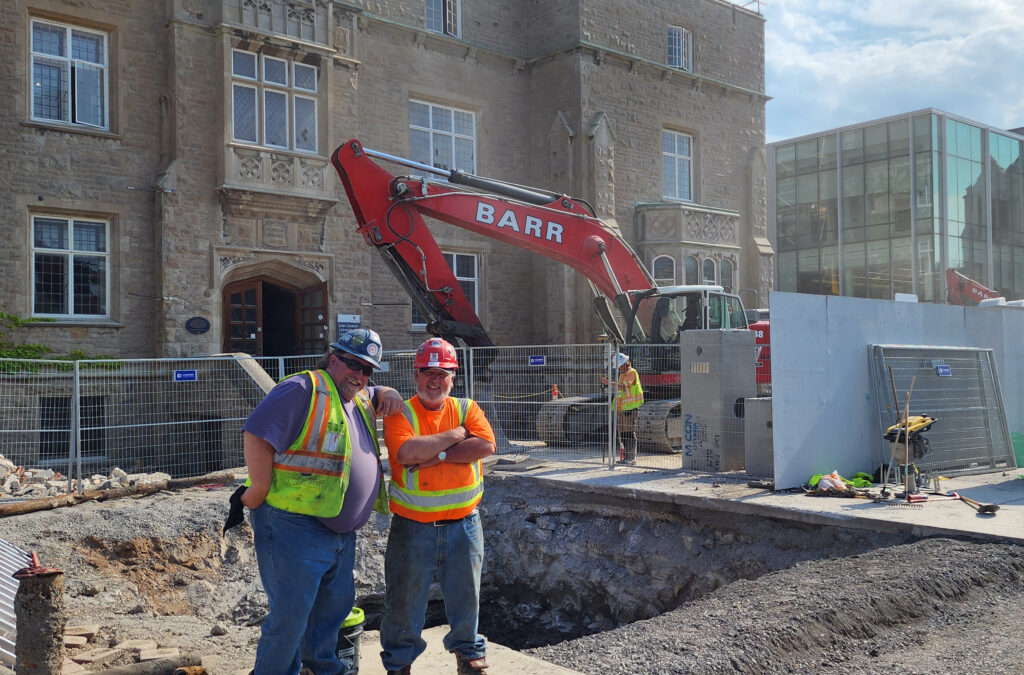 Brothers Ed Manion and Pat Rhode stand in front of JDUC construction site at Queens University