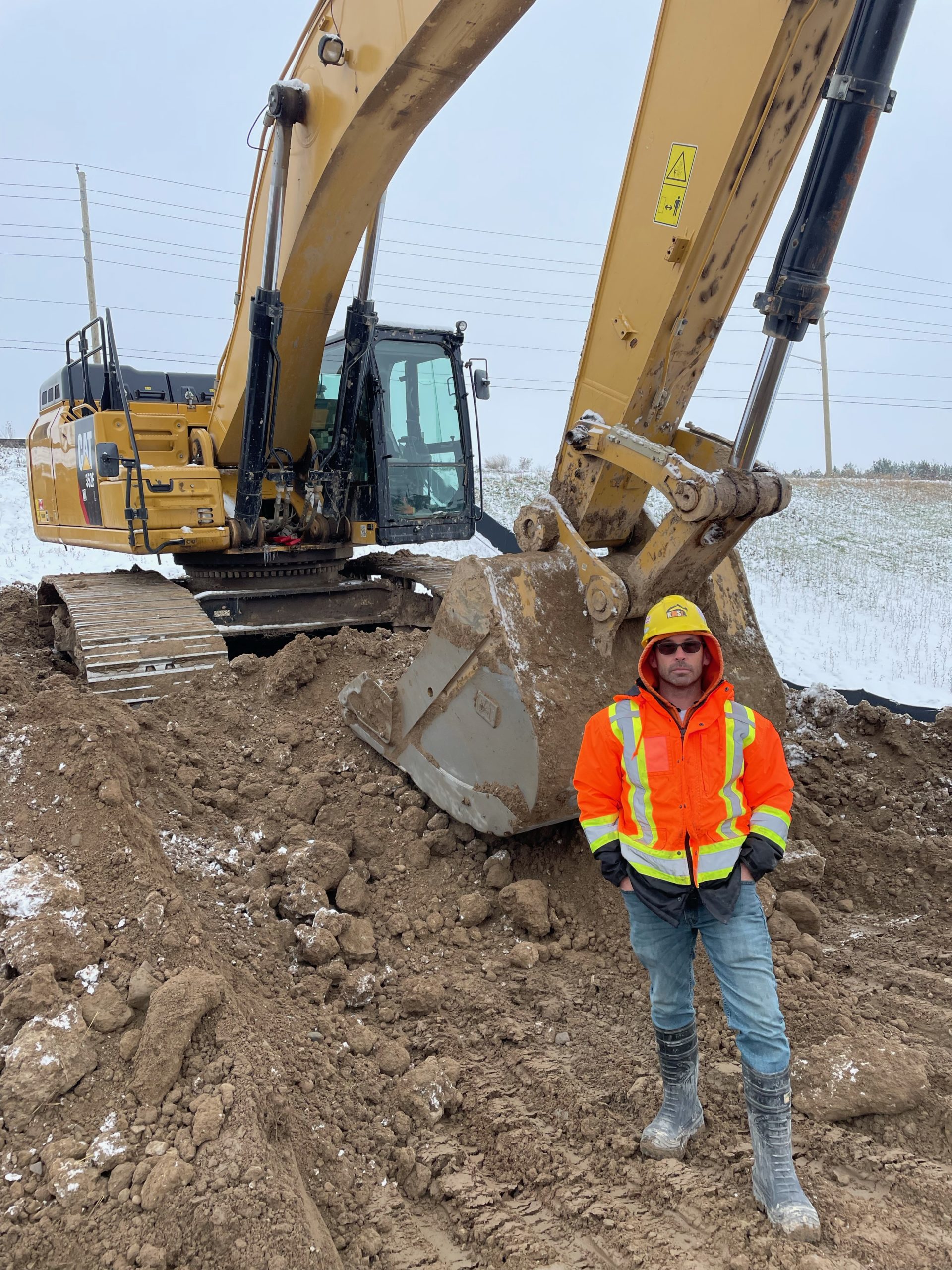 Local 793 member Robbie Evans standing in front of a 352F excavator.