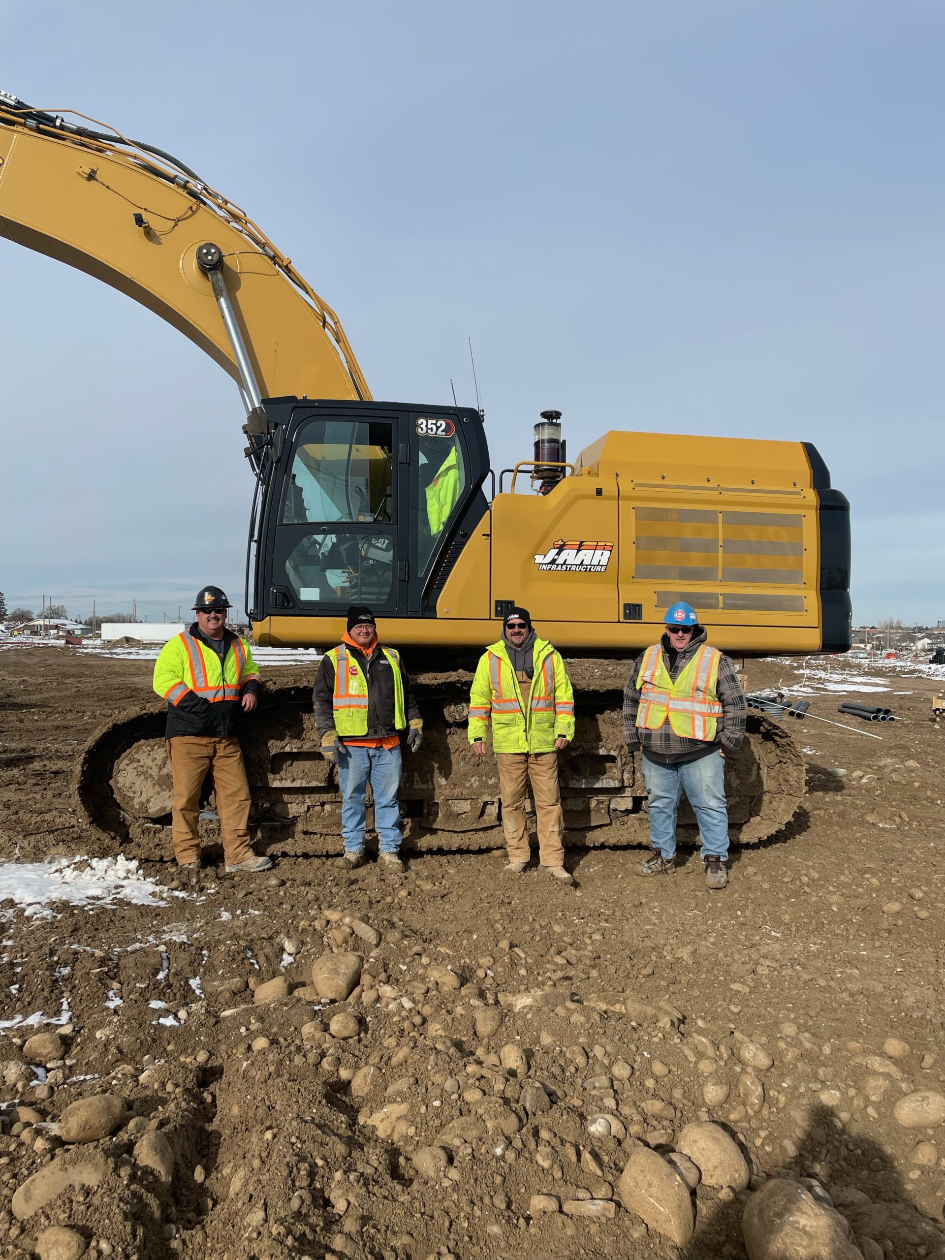Local 793 members Steve Wilson, Kevin Carruthers, Dan Jacques and Lee Carvalho with a CAT 352 excavator