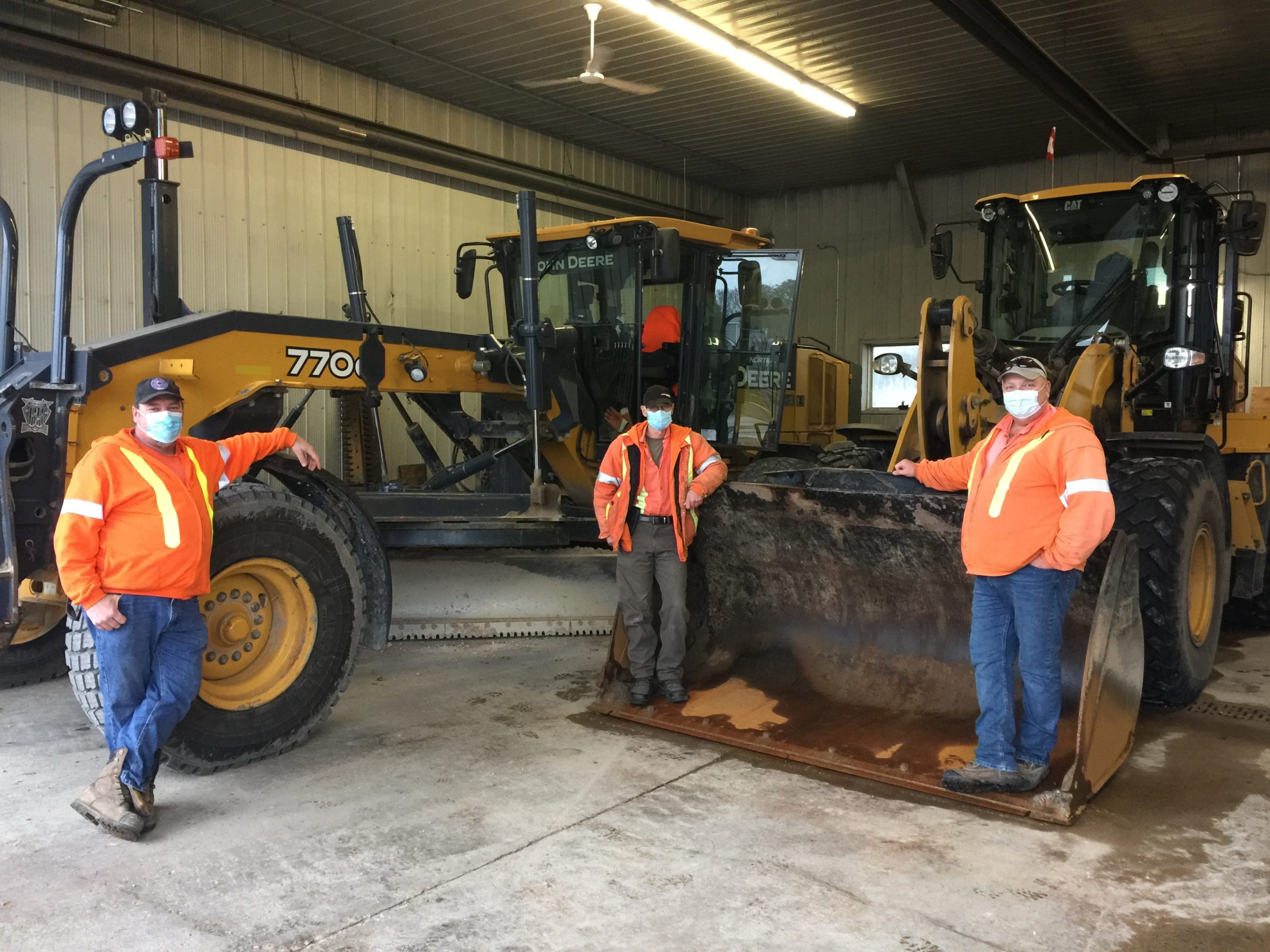 Local 793 members Tim Weber, Dave Spoenlein and steward Bob Blackwell standing in front of a Cat 770G grader and a Cat 930K loader at the Ripley Industrial Park shop.