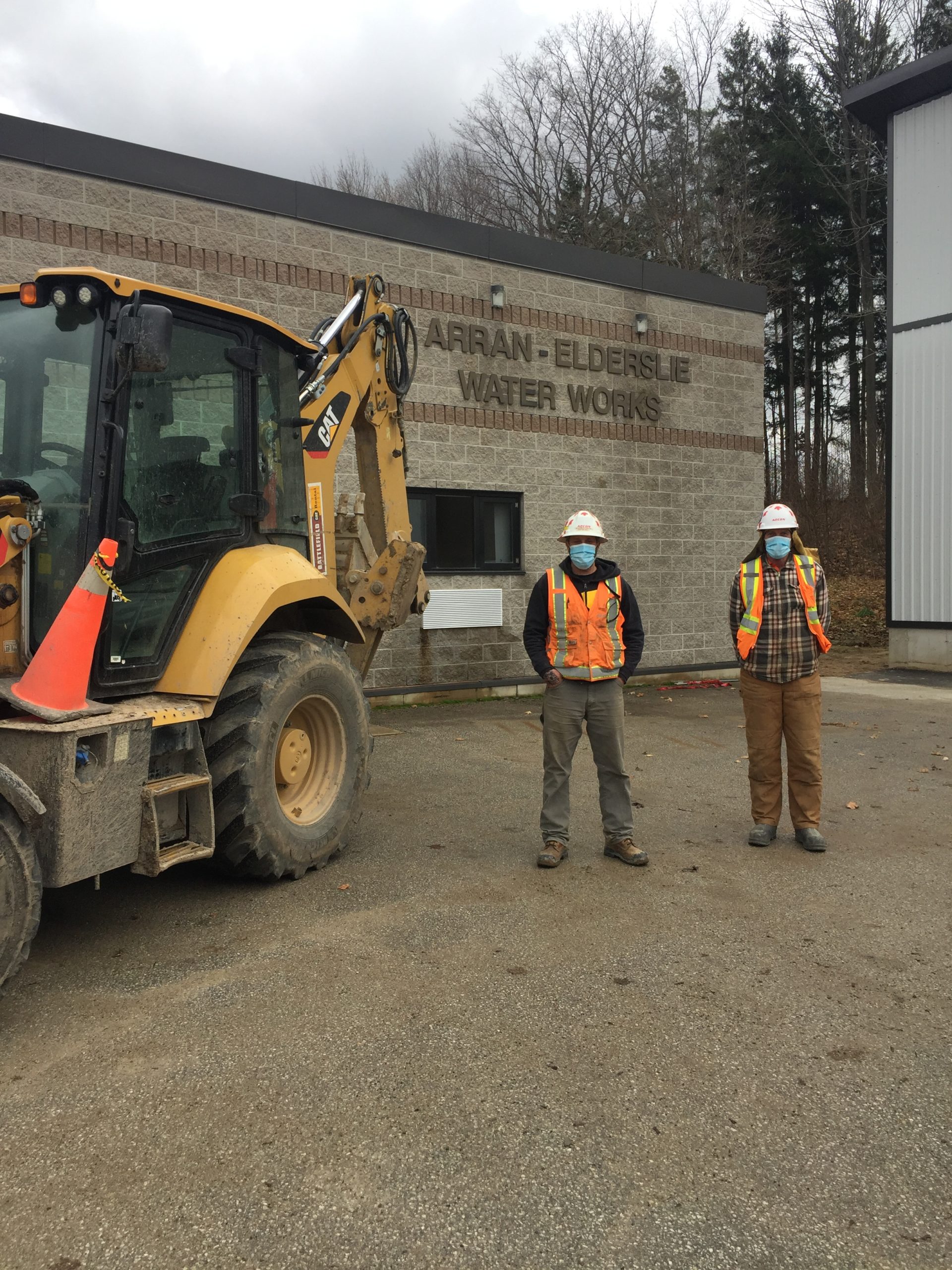 Local 793 members foreman Brent Hillman and Steve Van Eck with a Cat 420F backhoe.
