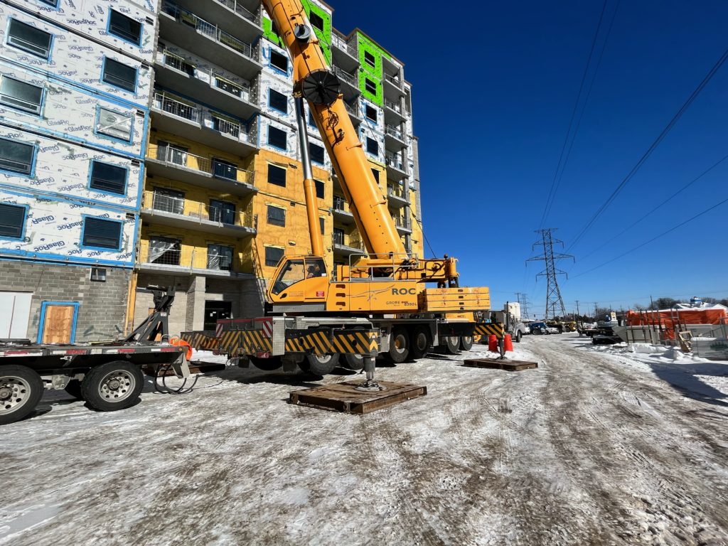 Wide shot of equipment on site with the building in the background