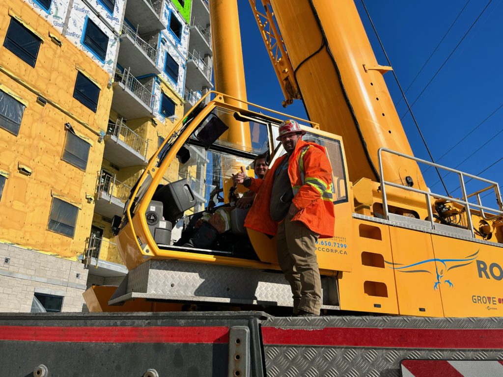 Two members operating and guiding the heavy equipment