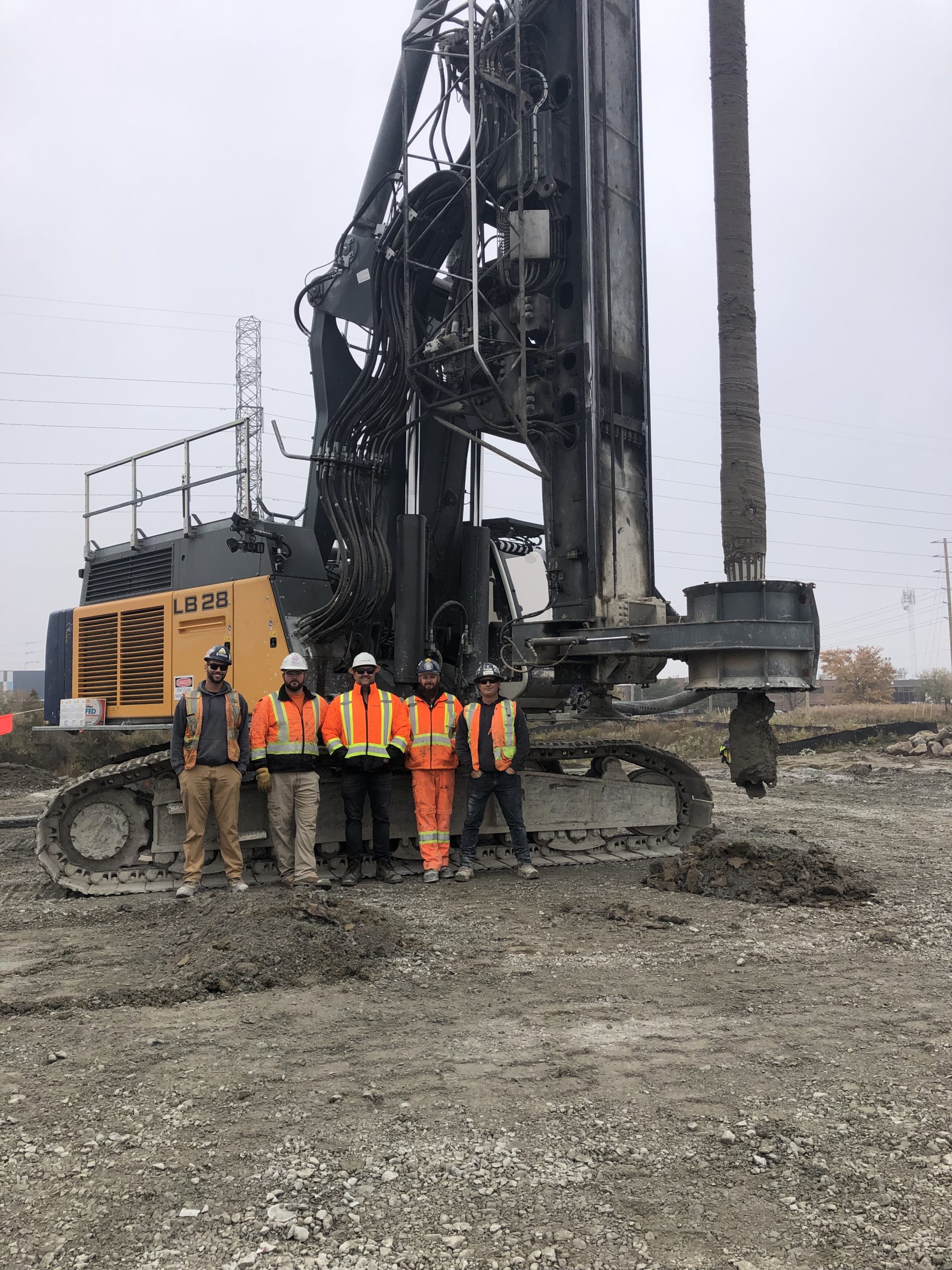 5 members in front of the drill rig